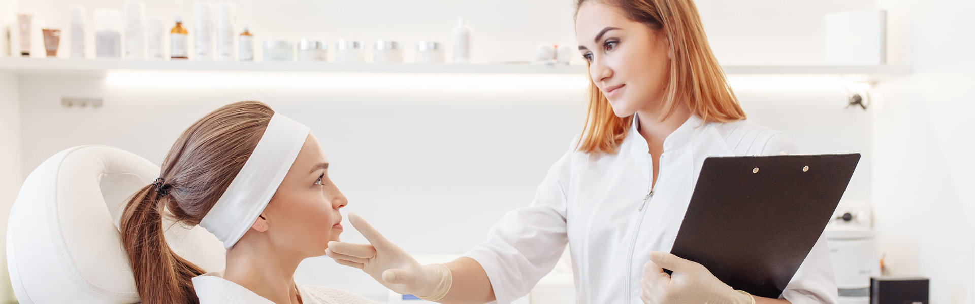 Young pretty woman came to a beauty salon and consults with a beautician on anti-aging treatments