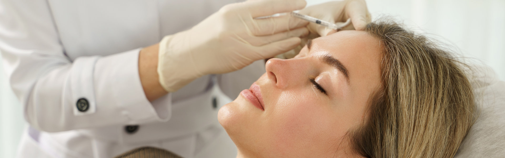 Woman during facial filler injections in aesthetic medical clinic